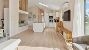 Una cuina moderna amb una illa central, terra de fusta i un gran finestral.
