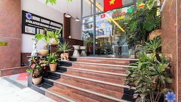 Hotellin sisäänkäynti, jossa on kyltti, jossa lukee ”Home Luxury Apartment”, ja portaat, jotka johtavat sisäänkäynnille.