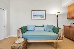 A room with a light blue sofa, a framed landscape painting, a floor lamp, and a wooden cabinet. - Desert Paradise | 3BR Legacy Villa (La Quinta)
