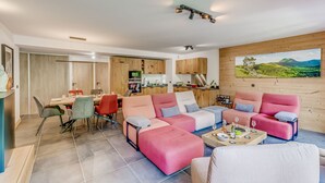 A modern living room with a dining area, kitchen, and a large window with a scenic view. - Family apartment 8 pers, balcony, parking, wifi included (Champagny-en-Vanoise)