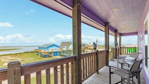 A wooden deck with a view of houses and a beach. - Purple Paradise- Beachy Fun, Bay & Beach Views! (Surfside Beach)