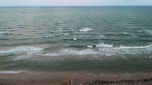 A beach with waves and a clear sky. - Purple Paradise- Beachy Fun, Bay & Beach Views! (Surfside Beach)