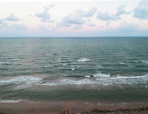 A beach with waves and a clear sky. - Purple Paradise- Beachy Fun, Bay & Beach Views! (Surfside Beach)