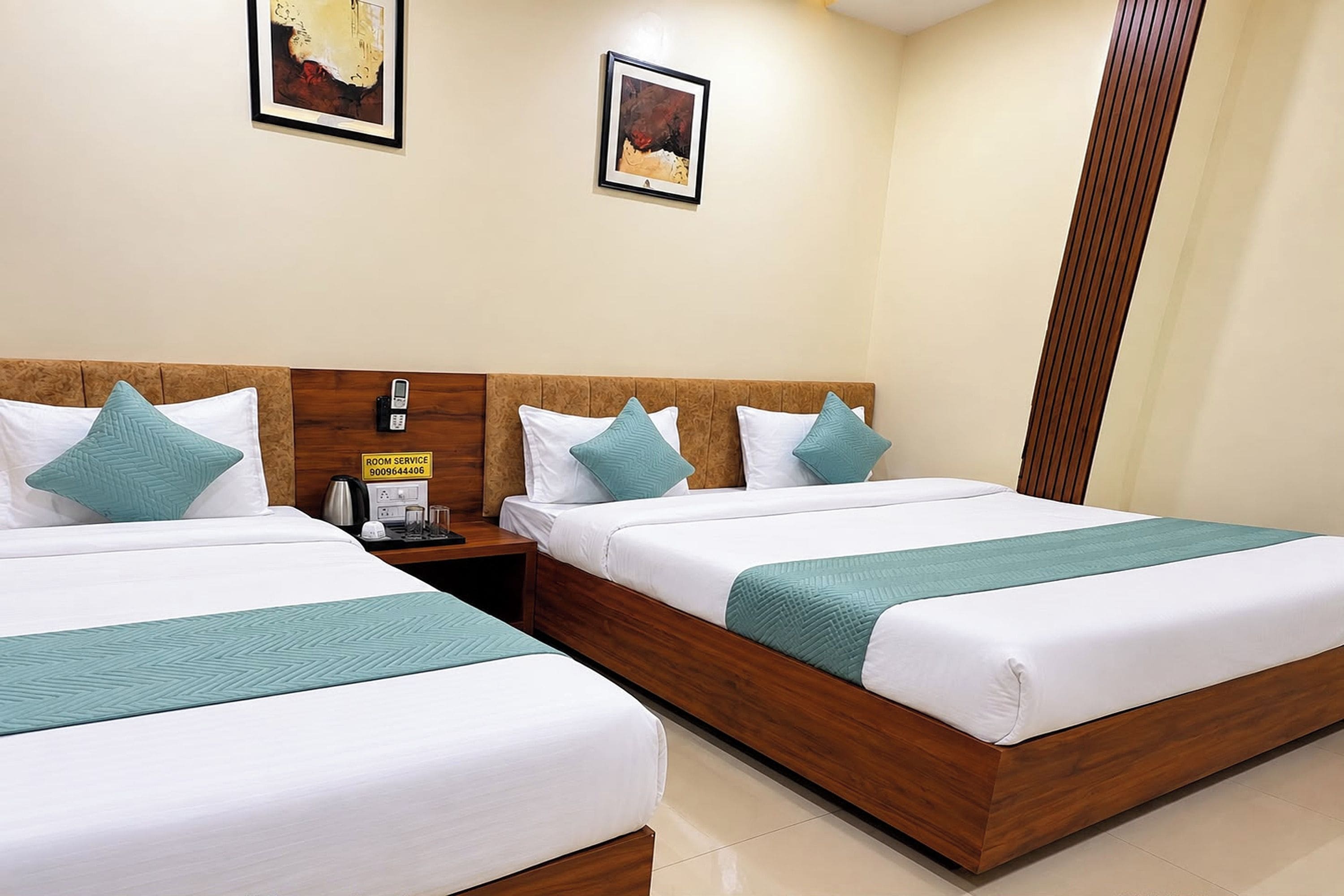 A hotel room with two beds, a wooden headboard, a bedside table with a phone, and a sign indicating room service.
