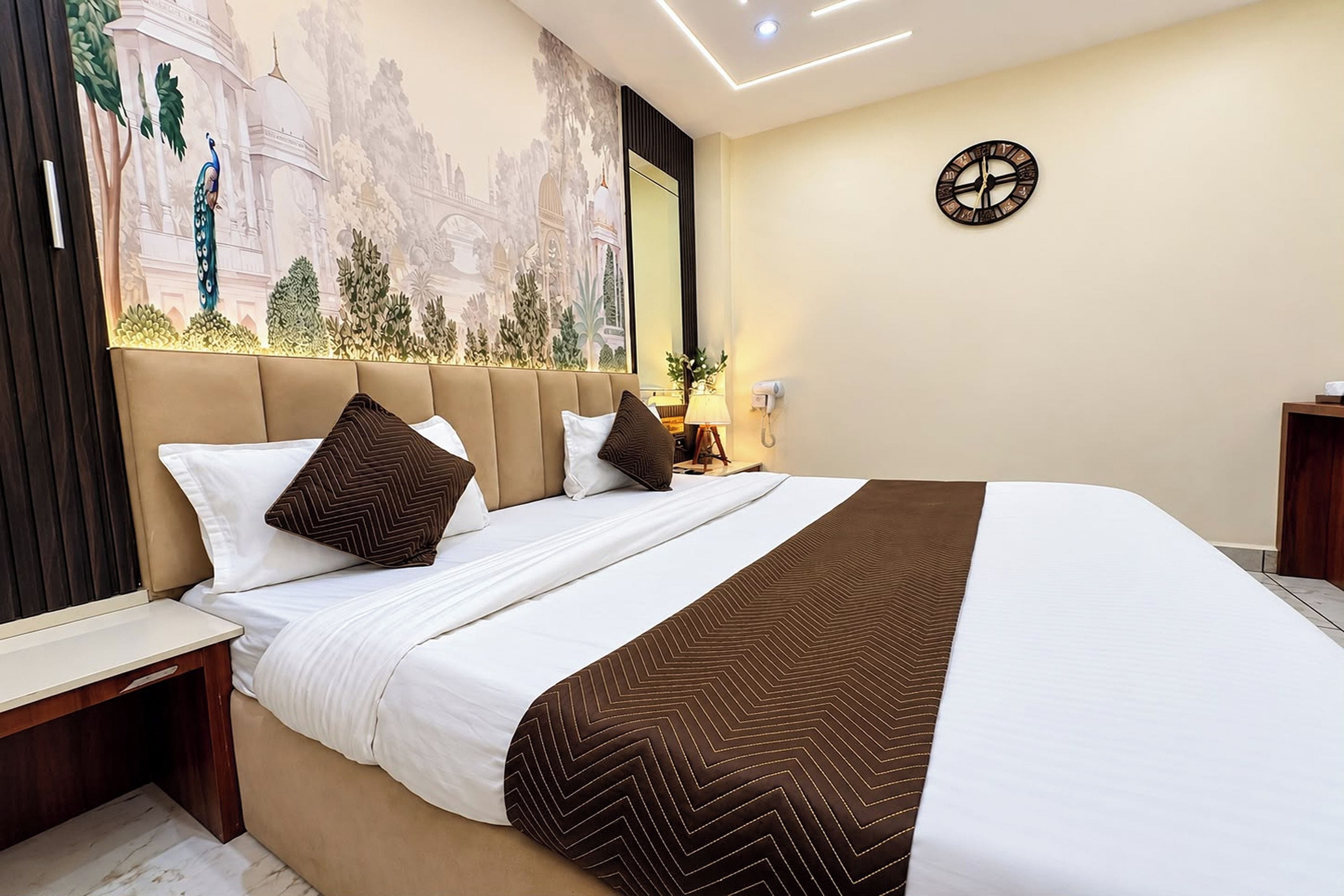 Una habitación de hotel con una cama grande, un reloj de pared y un mural.