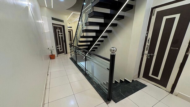 Un interior moderno con una escalera, una puerta y una planta en maceta.