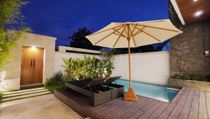 A modern outdoor pool area with a wooden deck, a lounge chair, and an umbrella. - SLOKAYANA VILLAS (Pecatu)