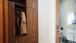 A wooden wardrobe with multiple compartments and a hanging rod. - SLOKAYANA VILLAS (Pecatu)