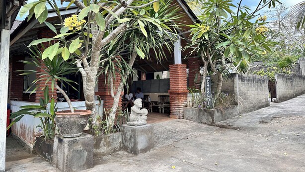 A traditional building with a covered porch, brick pillars, and potted plants. - BB Homestay Two (Pecatu)