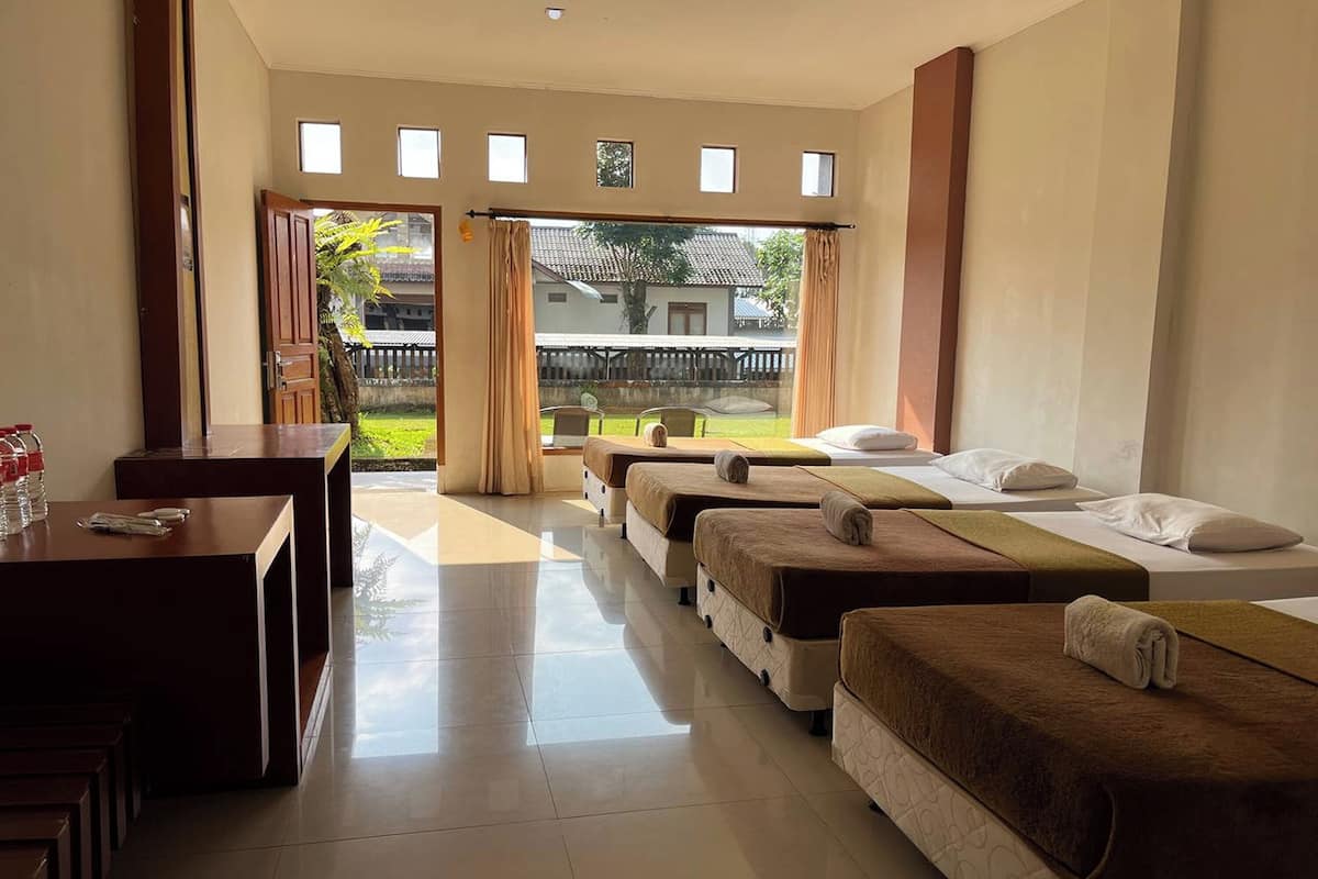 Habitación de hotel con cama, un escritorio pequeño y vistas al exterior.