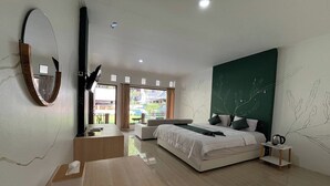 A modern bedroom with a large bed, a desk, a chair, a mirror, and a view of the outside. - Santa Monica Resort (Caringin)