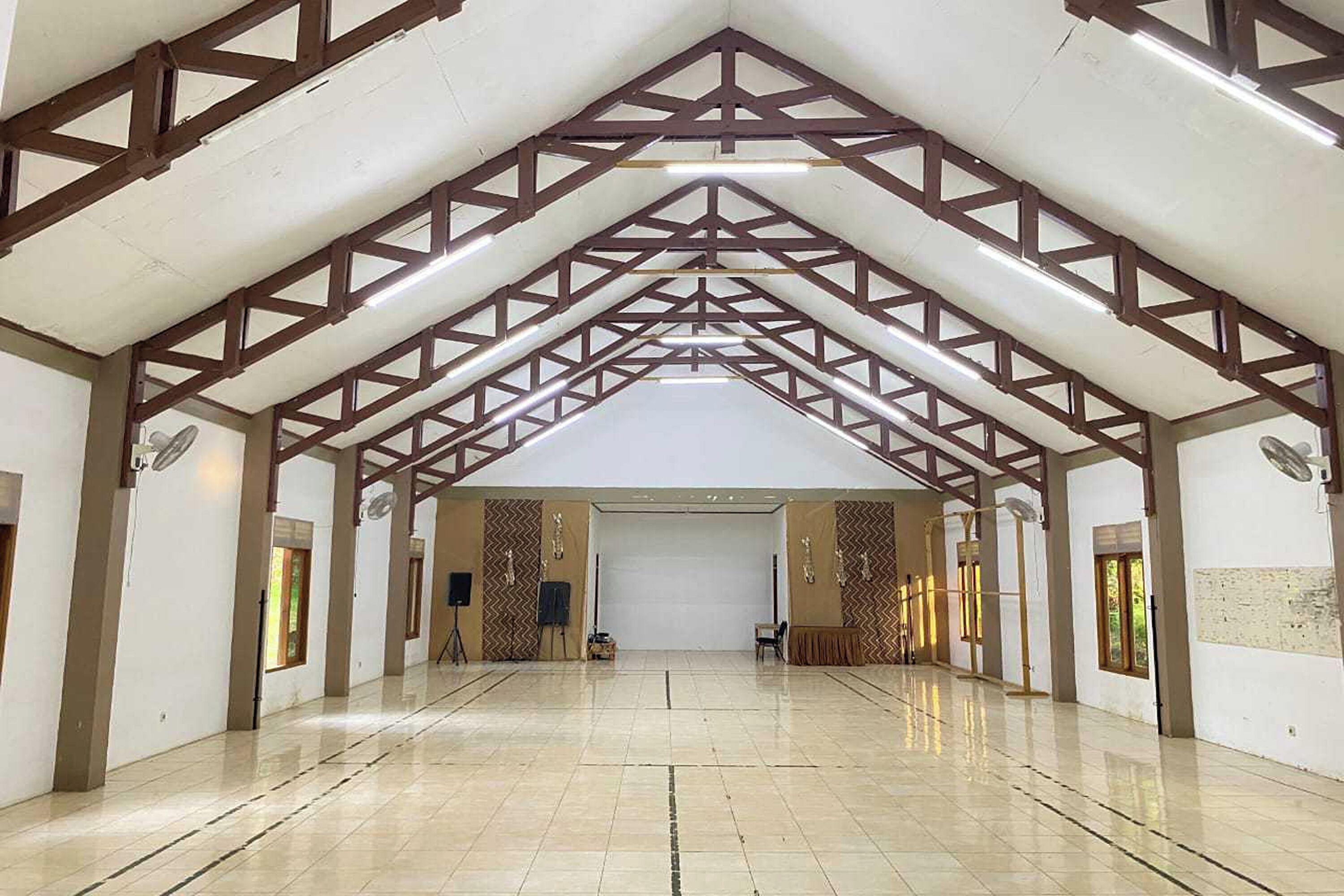 A spacious hall with a high ceiling and a truss structure.