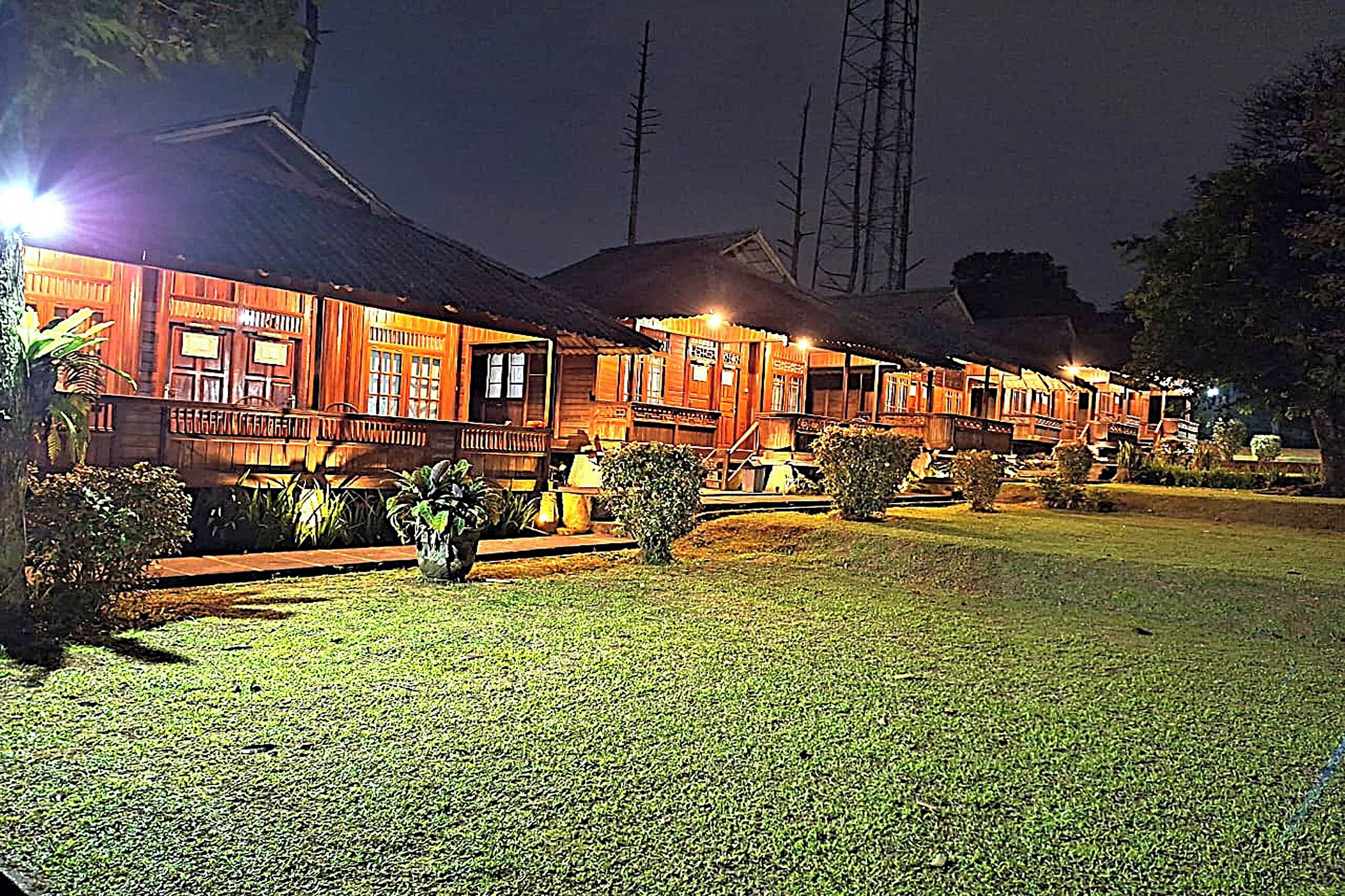 A row of wooden buildings with a well-maintained lawn in front.