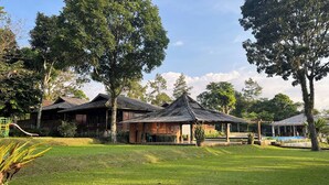 Un resort con varias cabañas de madera, un área verde y árboles.
