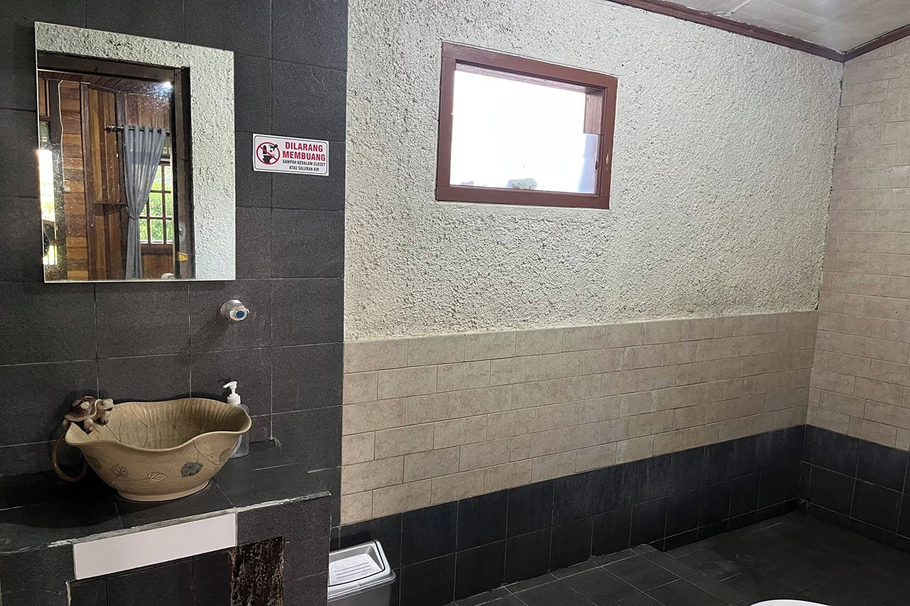 Une salle de bain équipée d’un lavabo, d’une fenêtre et d’un panneau indiquant un espace réservé aux fumeurs.