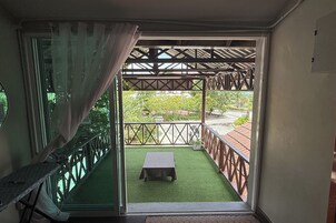 A room with a sliding glass door leading to an outdoor balcony with a table and chairs.