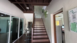 A staircase with wooden steps leading to a room with a bed and a fan. - Inapan Taman Herba (Kepala Batas)