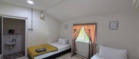 A room with two beds, a sink, and a window with curtains.