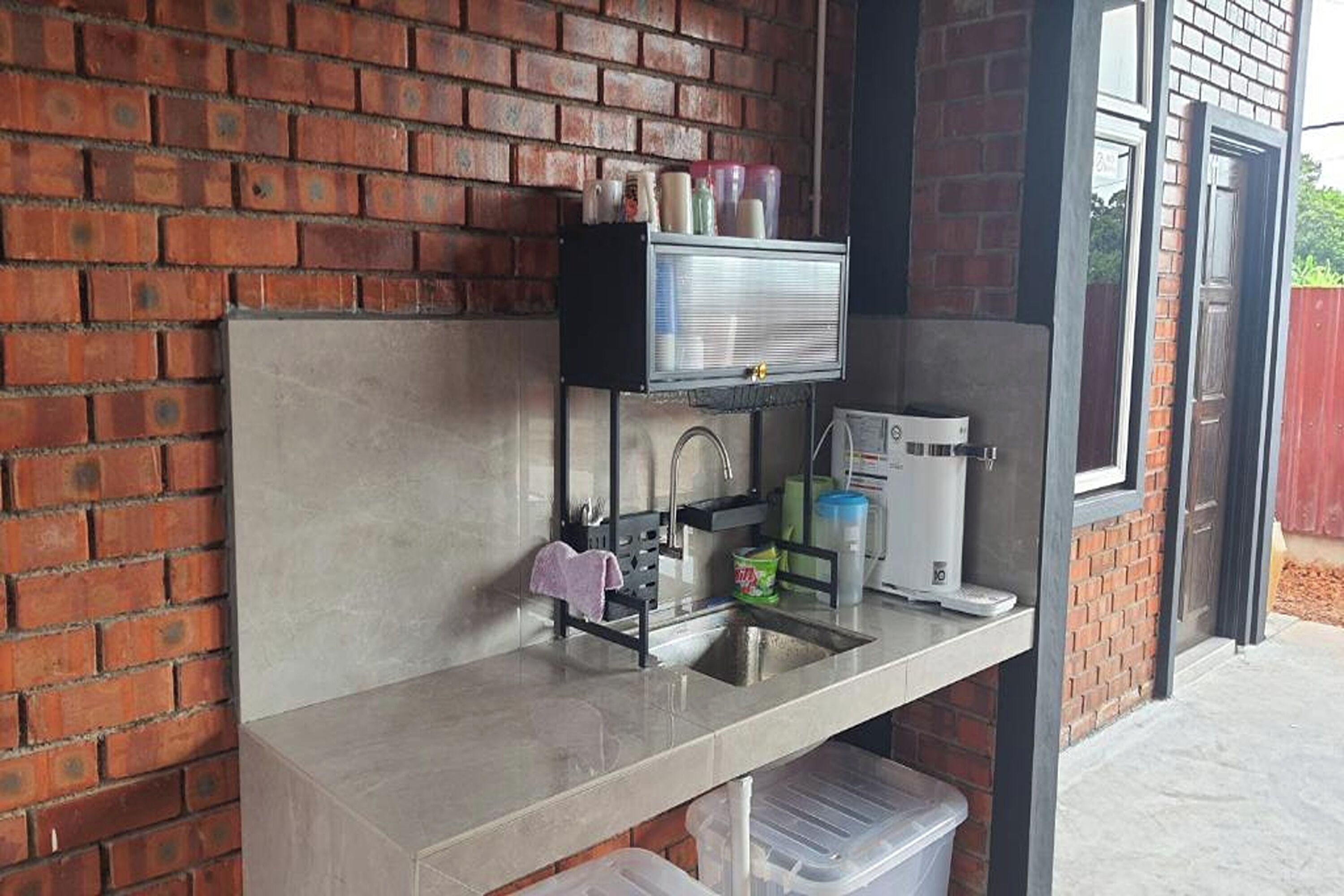 A compact kitchen with a sink, a coffee machine, and a small countertop.