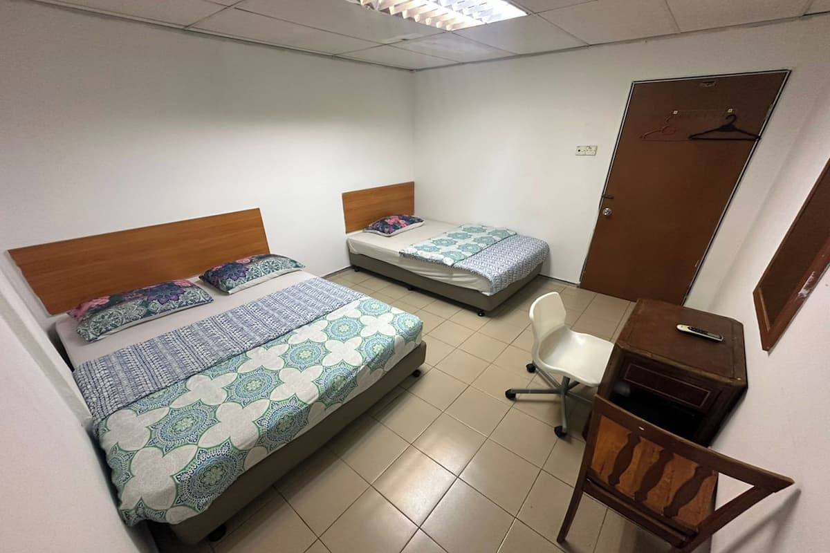 Une chambre avec deux lits, un bureau et une chaise.