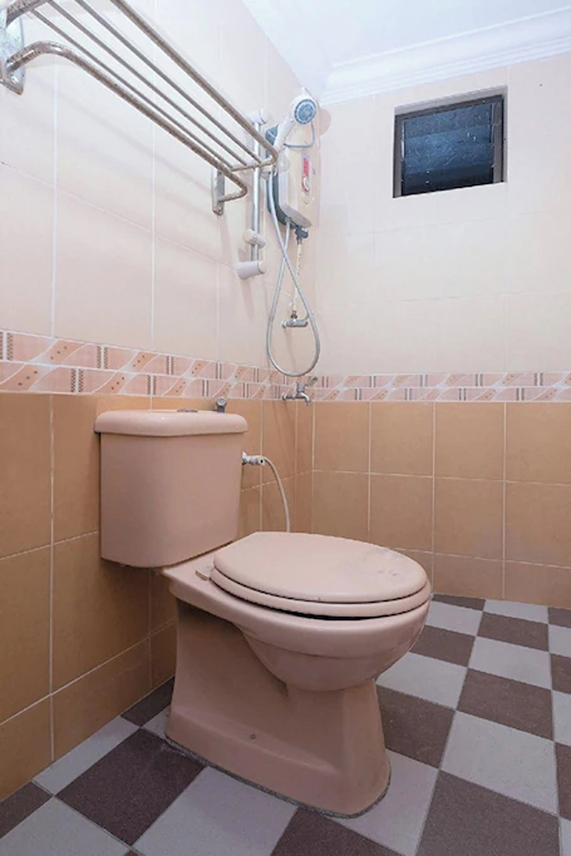 Un baño con inodoro, ducha y ventana.