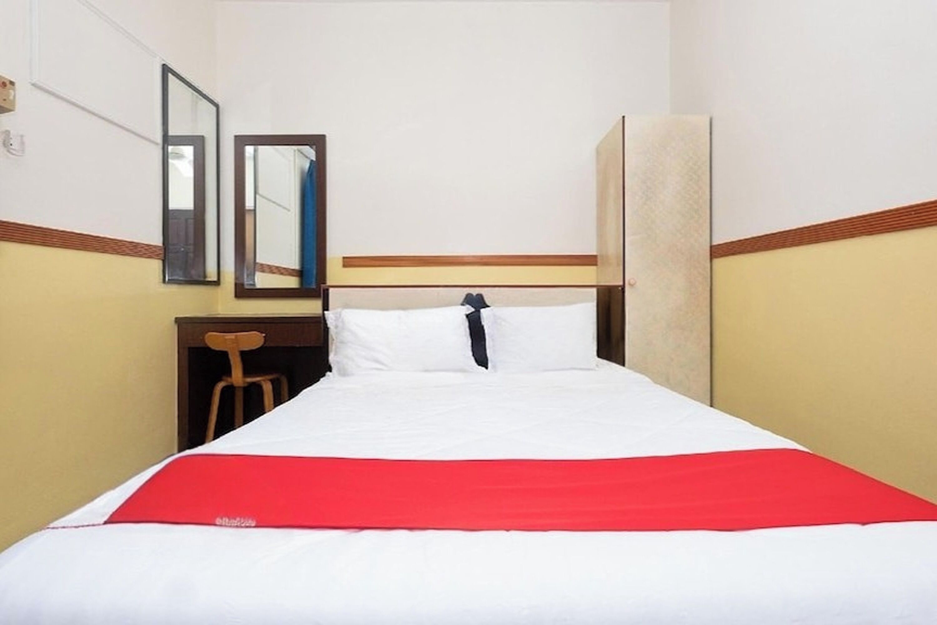 A hotel room with a bed, a desk, and a chair.