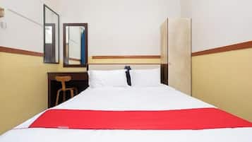 A hotel room with a bed, a desk, and a chair.