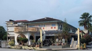 Un edificio de dos pisos con un balcón, una escalera y un letrero que dice 'MUTT VILLA INN'.