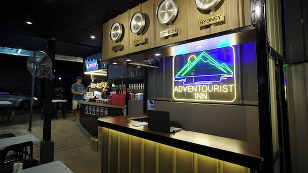 A hotel reception area with clocks indicating time in Sydney, London, Tokyo, and New York. - Adventourist Inn Coron (Coron)
