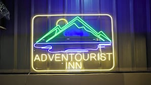 A neon sign for the Adventourist Inn with a mountain design. - Adventourist Inn Coron (Coron)