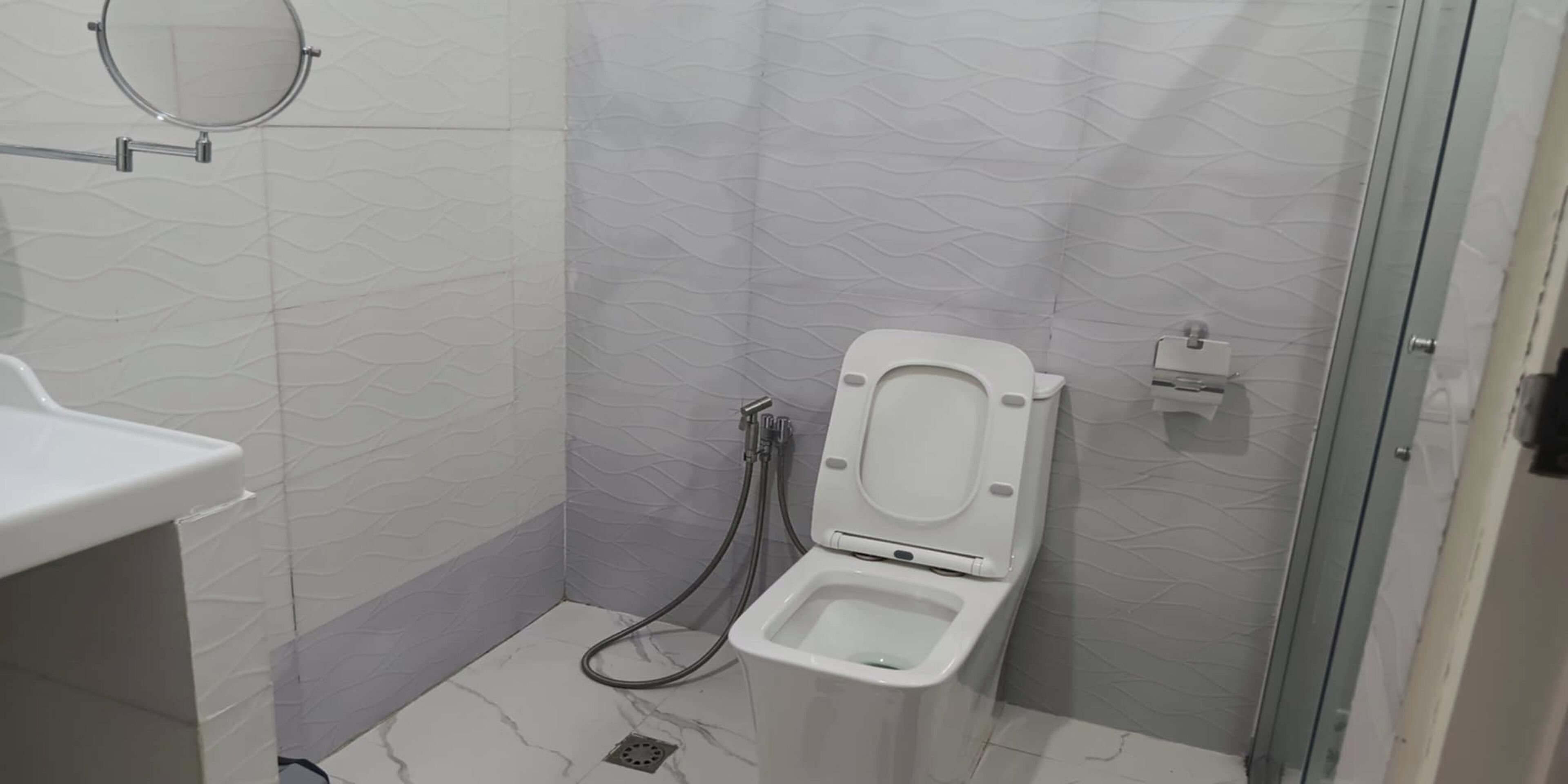Une salle de bain avec des toilettes, une douche et un lavabo.
