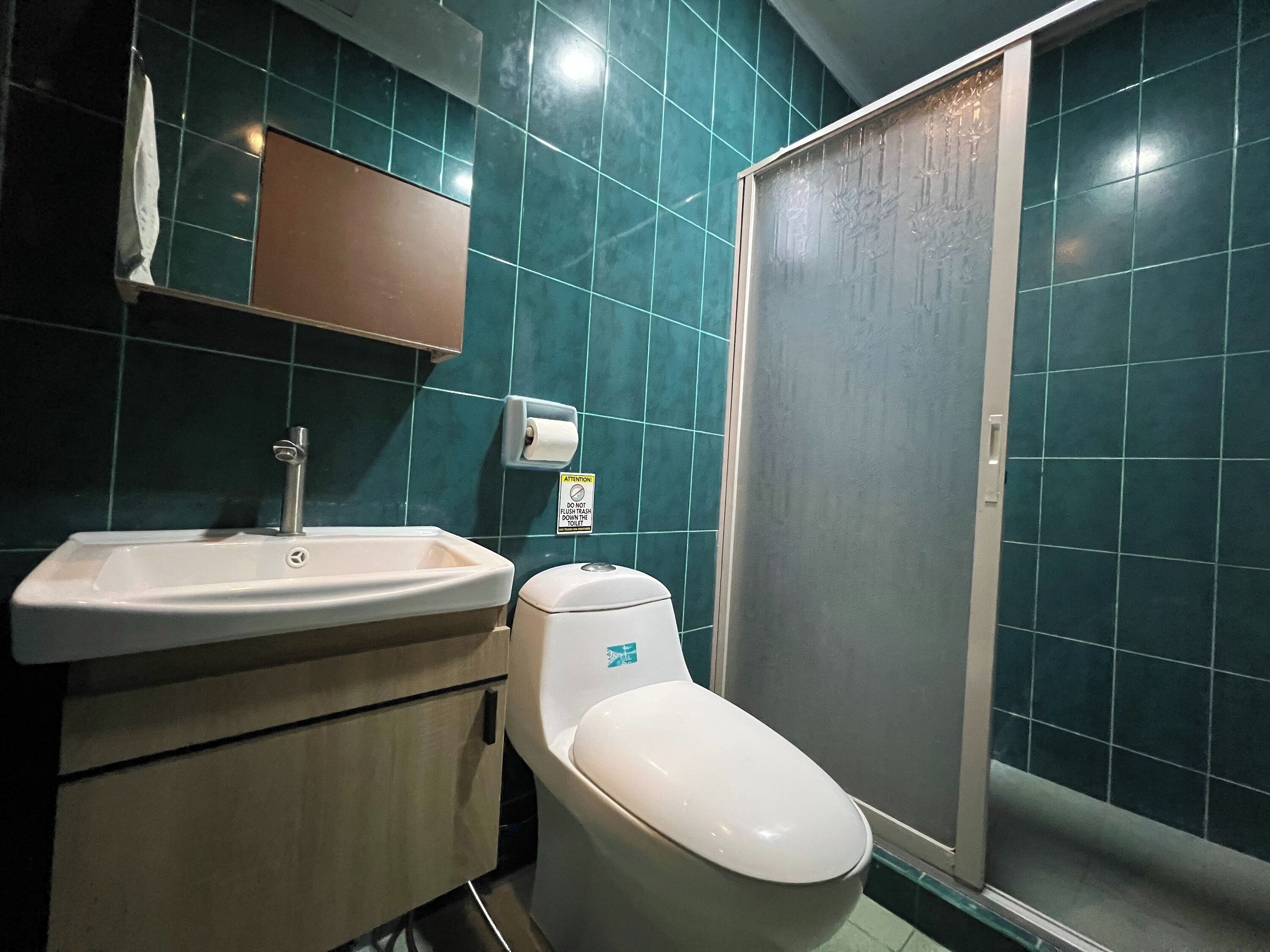 Un baño con lavamanos, inodoro y cabina de ducha.