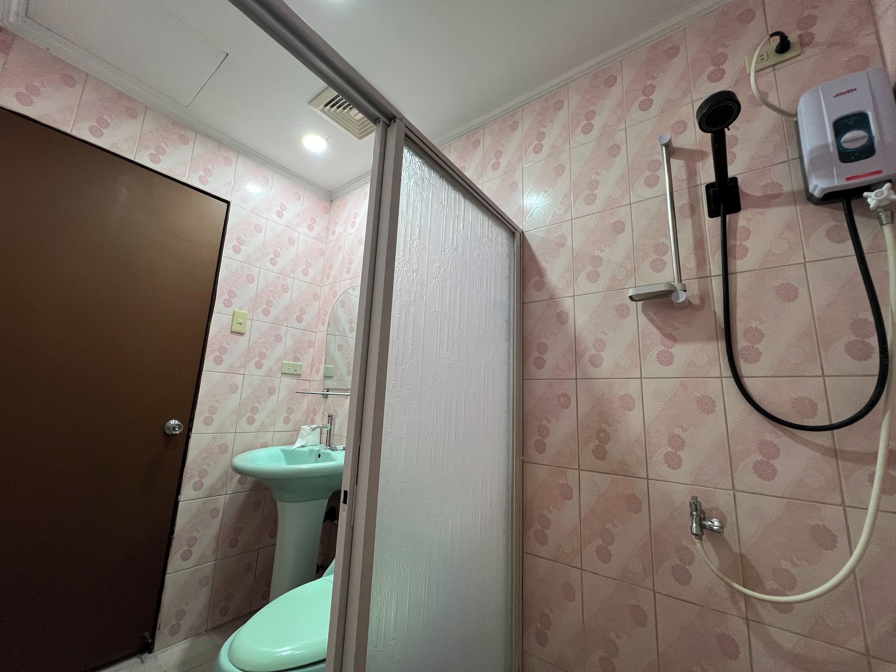 A bathroom with a toilet, sink, and shower.