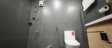 Un baño moderno con ducha, inodoro y lavamanos.