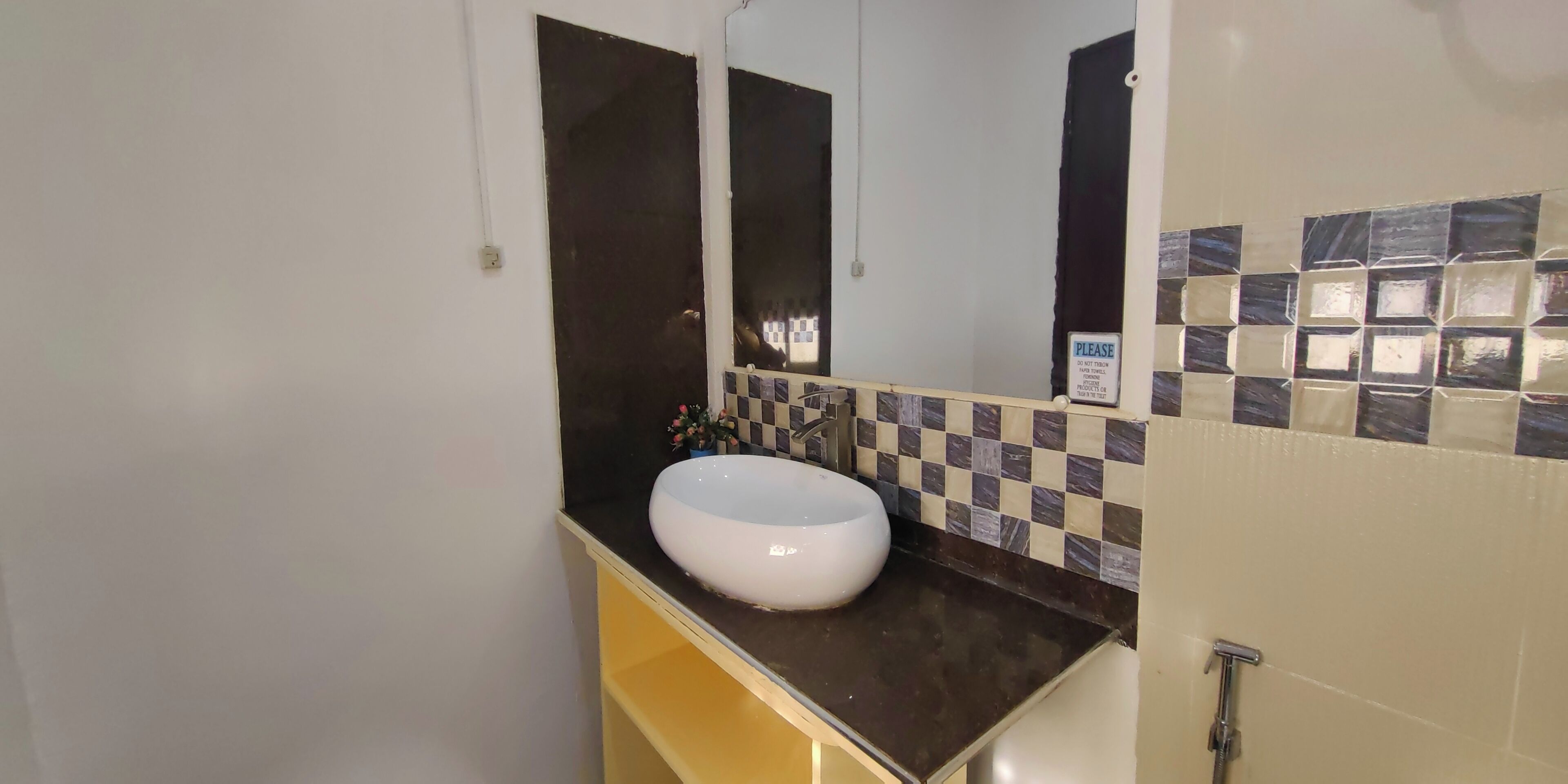 A bathroom with a white sink, a mirror, and a tiled backsplash.