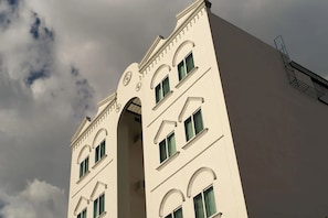 Ein hohes Gebäude mit Rundbogenfenstern und einem zentralen Bogenportal.