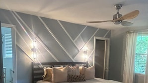 A bedroom with a bed, a ceiling fan, and a window with curtains. - A cozy house with best location (Charlotte)