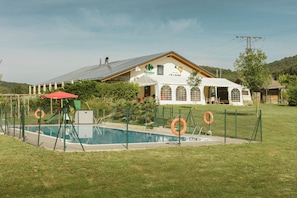 Piscina a l'aire lliure de temporada i para-sols