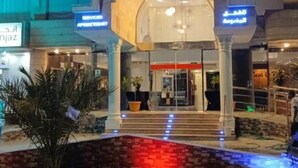 Entrada d'hotel amb una arcada destacada i senyalització il·luminada.