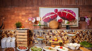 Un dispositiu de buffet amb diversos plats, un gran quadre floral i un fons de pared de maó.