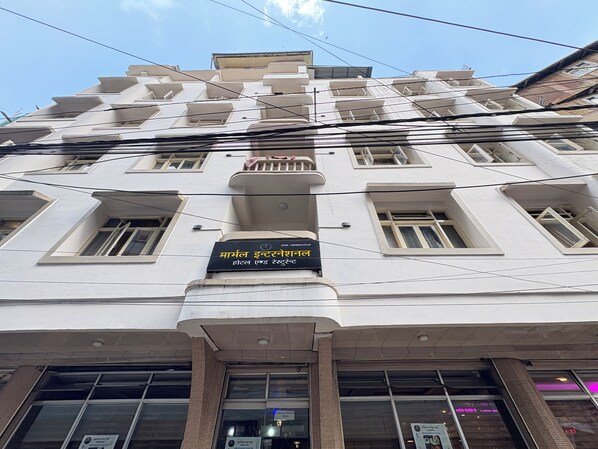 A multi-story building with a sign indicating it is a hotel and restaurant. - Hotel Marvel International & Restaurant (Darjeeling)