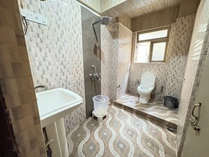 Chambre Quadruple Deluxe, vue ville | Salle de bain | Douche, douche à « effet pluie », serviettes fournies, savon