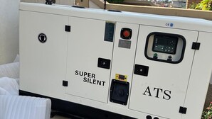 A white ATS Super Silent portable generator with a control panel, located outdoors.