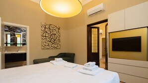 Une chambre d’hôtel avec un grand lit, une télévision et une œuvre d’art accrochée au mur.
