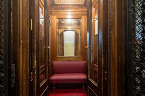 A narrow hallway with wooden paneling and a red bench. - Tuscan Refined Retreat (Firenze)