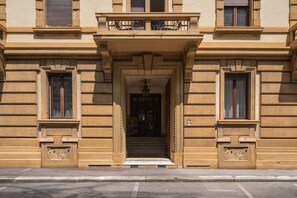 A building with a grand entrance, large windows, and a balcony with wrought iron railings. - Tuscan Refined Retreat (Firenze)