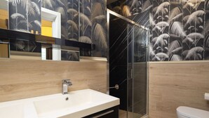 A modern bathroom with a glass shower enclosure, a white sink, and a toilet. - Tuscan Refined Retreat (Firenze)