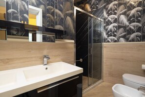 A modern bathroom with a glass shower enclosure, a white sink, and a toilet. - Tuscan Refined Retreat (Firenze)