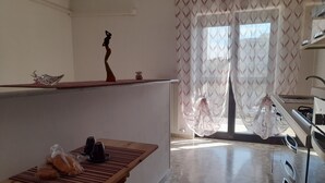 A kitchen with a wooden countertop, a sink, and a window with patterned curtains. - An oasis of tranquility in a strategic location, "Belvedere da Madia "in Monopoli. (Monopoli)