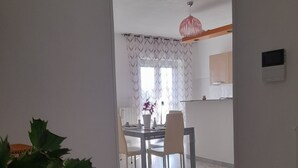 A dining area with a table and chairs, a potted plant, and a patterned rug. - An oasis of tranquility in a strategic location, "Belvedere da Madia "in Monopoli. (Monopoli)